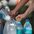 Menschen füllen Wasserflaschen auf